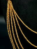 Detail of the left shoulder tassel drop on the necklace showing all 5 strands of diamond-cut twisted beads gathering into a cascading tassel