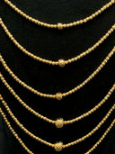 Close-up of the 5 necklace strands showing the diamond-cut twisted bead texture and the single larger twisted ball accent centered on each strand
