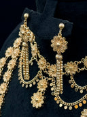 Macro detail of the drop earrings showing ball stud top, filigree daisy connector, coiled bar drop, and coin disc fringe alongside the collar necklace daisy stations