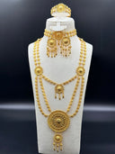 Full view of the 6-piece gold-tone arabesque bridal jewelry set displayed on a bust, showing layered necklaces, choker, drop earrings, and ring