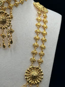 Close-up of the quatrefoil link chain and mid-level sunburst medallion pendant with teardrop drops