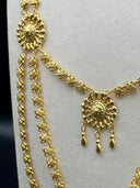 Side detail showing the layered quatrefoil link chains and a mid-level floral medallion with teardrop drops